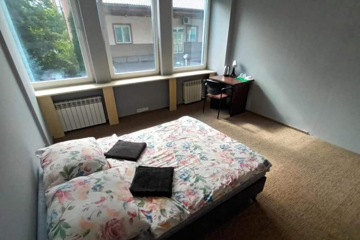 Ein Schlafzimmer mit einem Bett, einem Schreibtisch und einer Heizung.