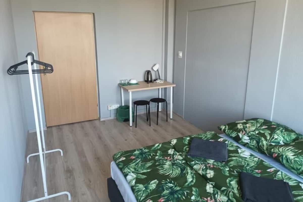 Ein Zimmer mit einem Bett, einem Schreibtisch und einem Stuhl.