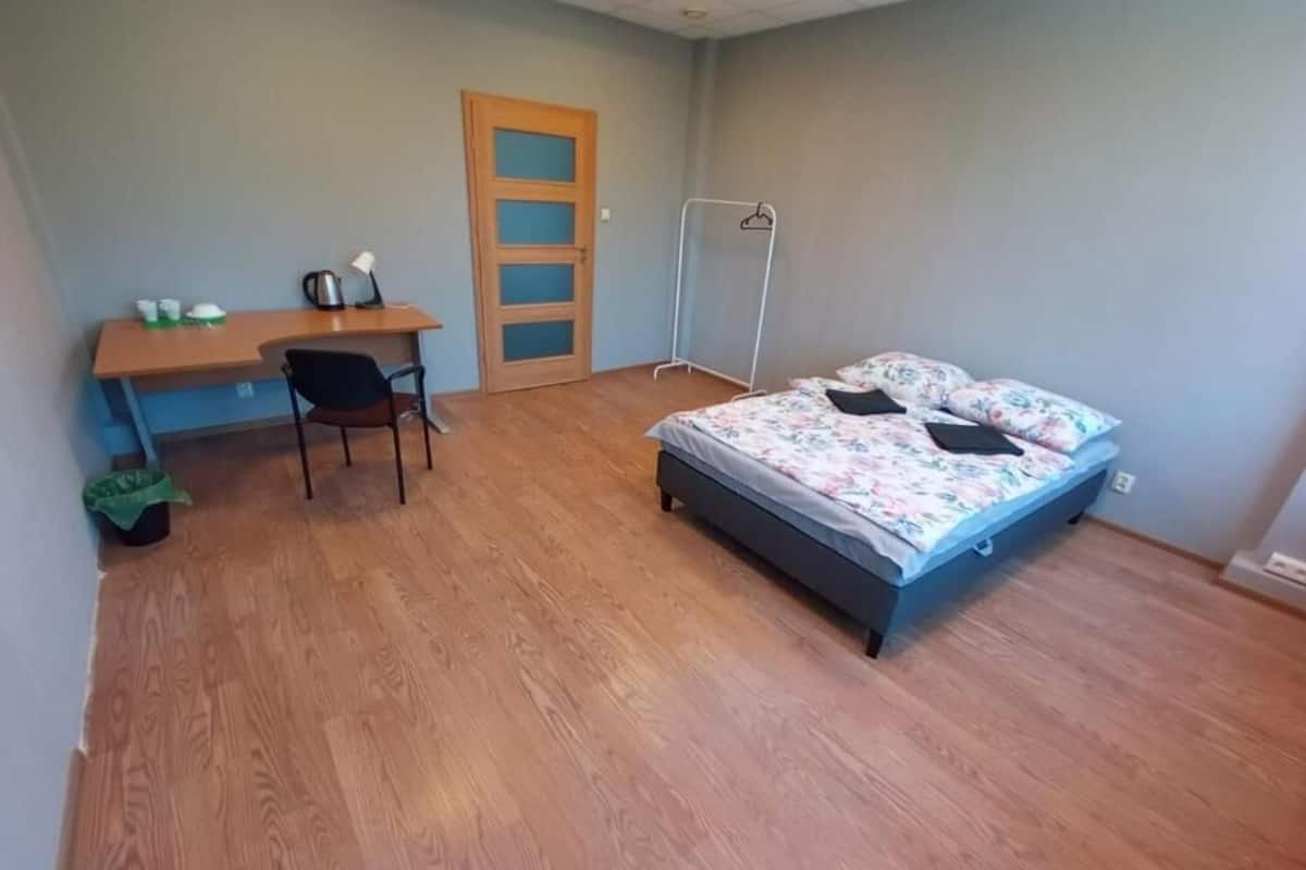 Ein Schlafzimmer mit einem Bett, einem Schreibtisch, einem Sessel und einem Kleiderschrank.