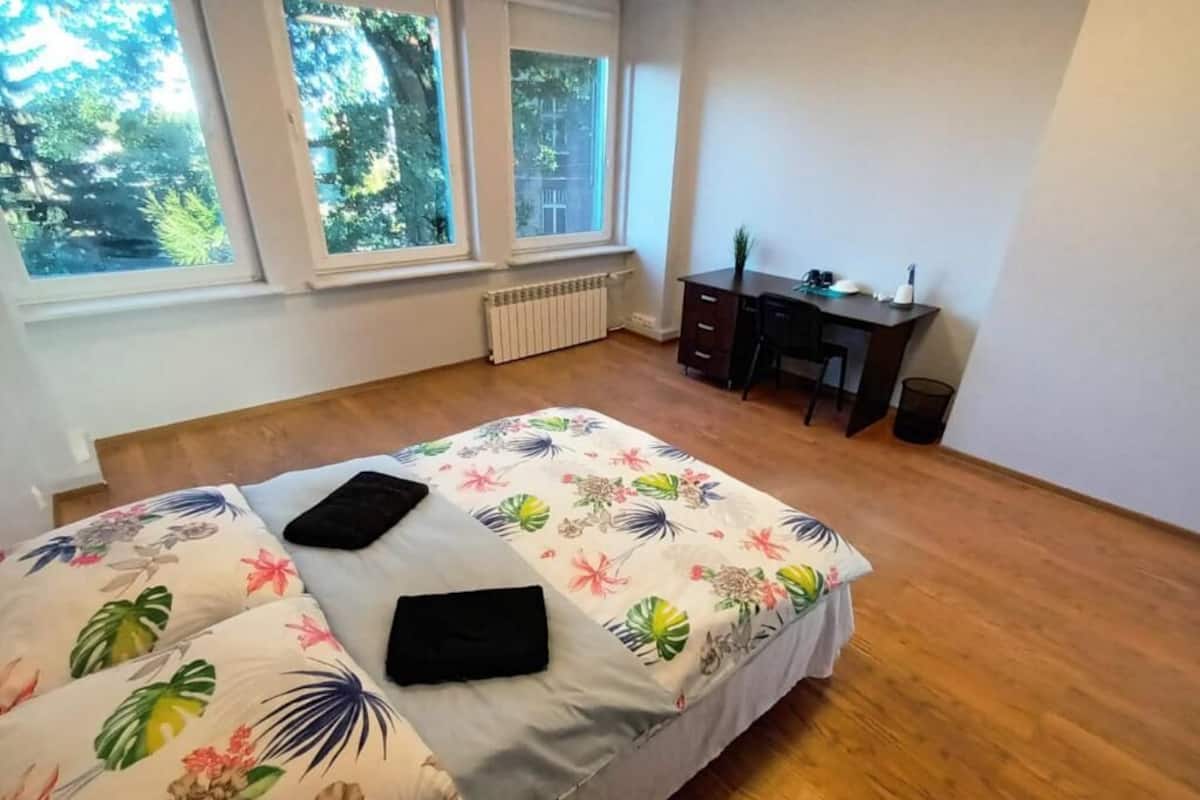 Ein Schlafzimmer mit einem Bett, einem Schreibtisch und einer Heizung.