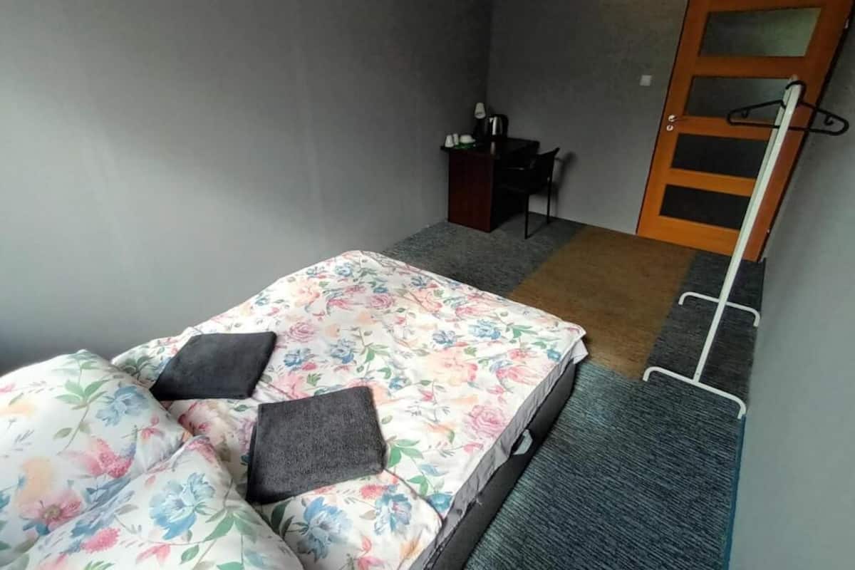 Ein Schlafzimmer mit Bett, Schreibtisch und Tür.