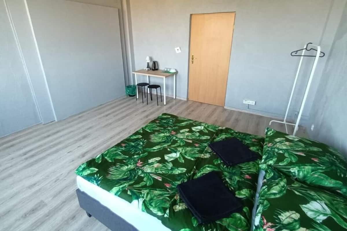 Ein Zimmer mit einem Bett, einem Schreibtisch und einer Tür.