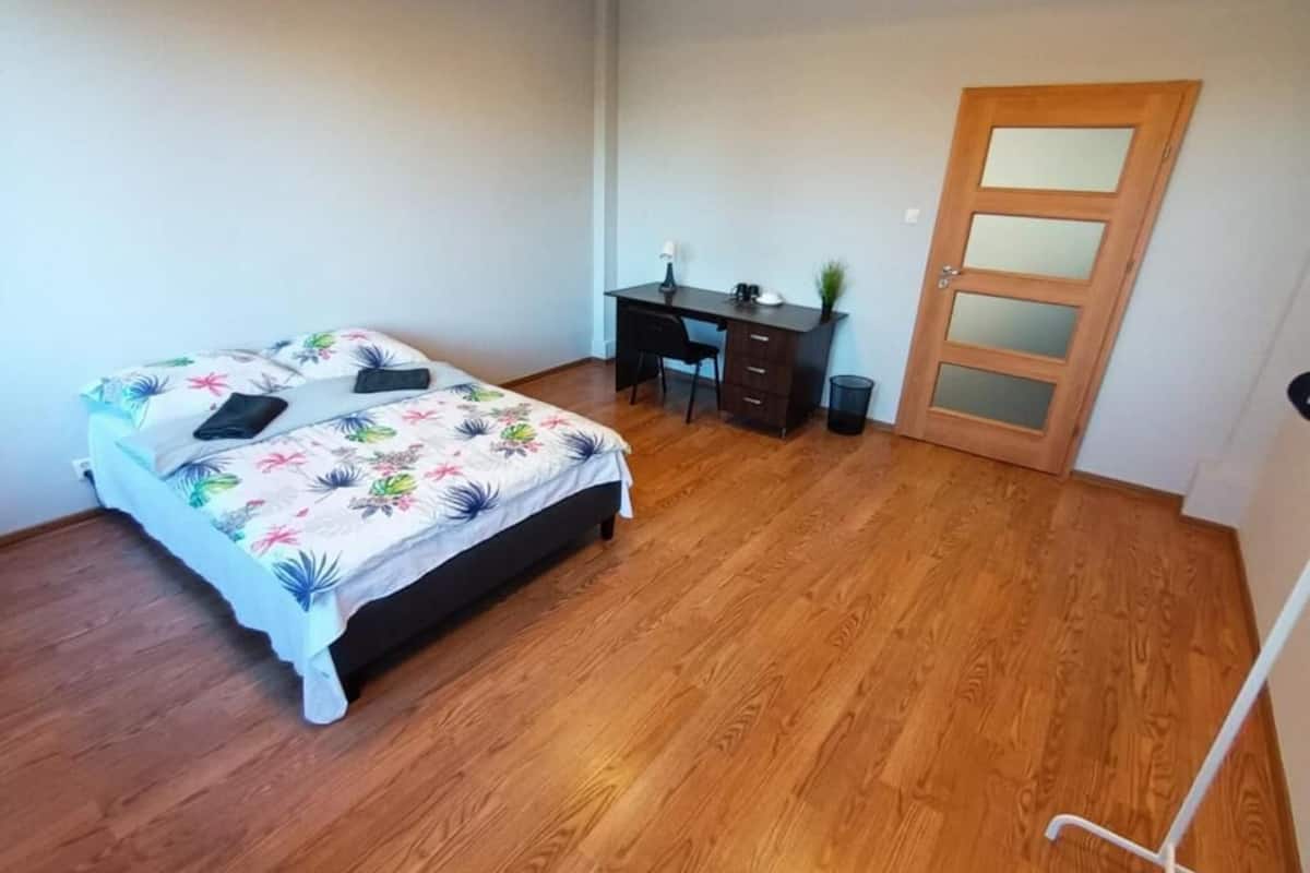 Ein Schlafzimmer mit einem Bett, einem Schreibtisch und einer Tür.