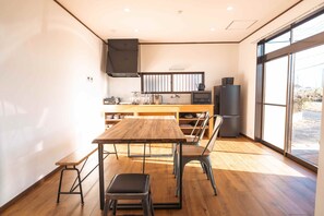 Una cucina moderna con un tavolo e sedie in legno, forno integrato e un'ampia finestra che garantisce luce naturale.