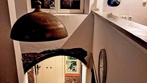 A kitchen with a hanging light fixture, a clock, and a door leading to another room. - Stilvolles Landhaus an der Algarve by Interhome (Algoz)