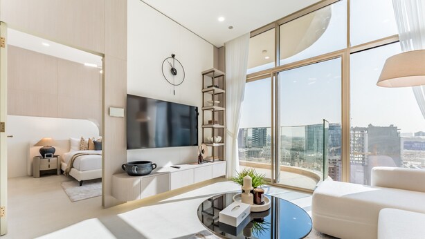 Ein modernes Wohnzimmer mit großem Fenster, Flachbildfernseher, Couchtisch und einer Couch.