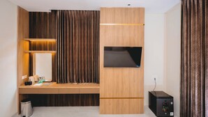 A modern hotel room with a wooden desk, a flat-screen TV, and a compact black printer. - Front One Hotel Mesir Surabaya (Surabaya)