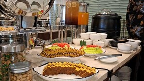 A buffet with various food items, including sliced meats, fruits, and beverages. - Front One Hotel Mesir Surabaya (Surabaya)