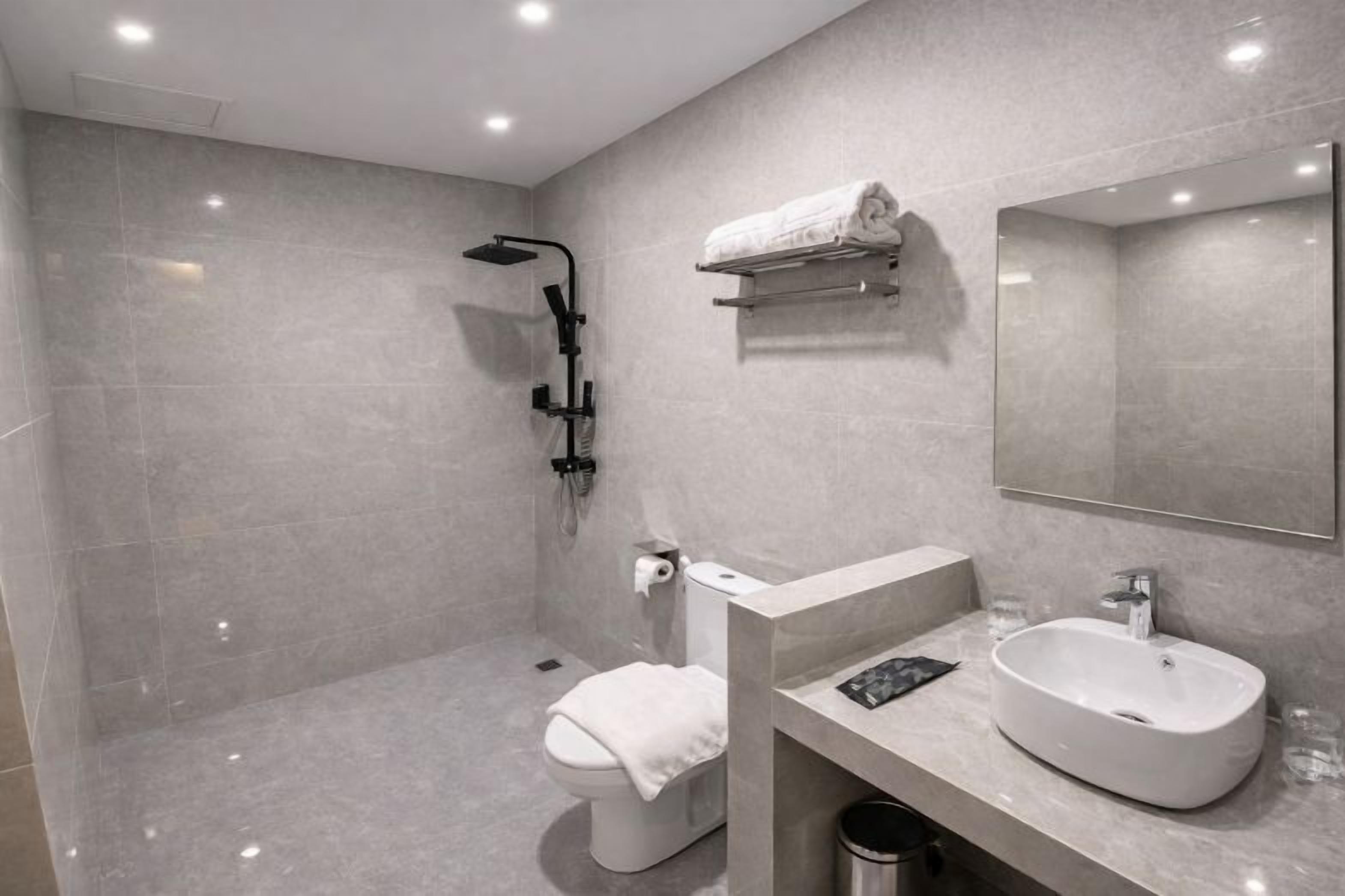 Un baño moderno con inodoro, lavamanos y ducha.