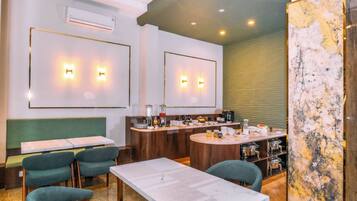 Un área de comedor moderna con barra, asientos y una pared de acento de mármol.