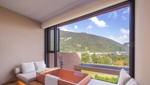 A modern bedroom with a large window, a bathtub, and a sofa. - Zhangjiajie Shisuji Hotel - Zhangjiajie National Forest Park Avatar Scenic Area Branch (Zhangjiajie)