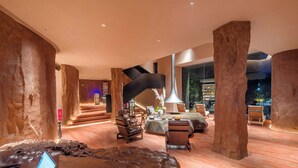 A spacious lobby with a modern design, featuring a central staircase, seating areas, and a bar. - Zhangjiajie Shisuji Hotel - Zhangjiajie National Forest Park Avatar Scenic Area Branch (Zhangjiajie)