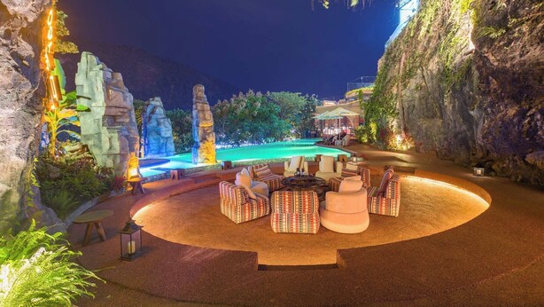 A nighttime resort with a pool, outdoor seating, and a mountainous backdrop. - Zhangjiajie Shisuji Hotel - Zhangjiajie National Forest Park Avatar Scenic Area Branch (Zhangjiajie)