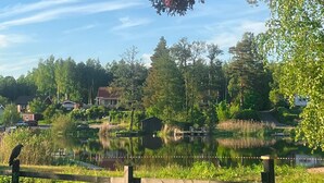 A serene lakeside view with houses, trees, and a dock.