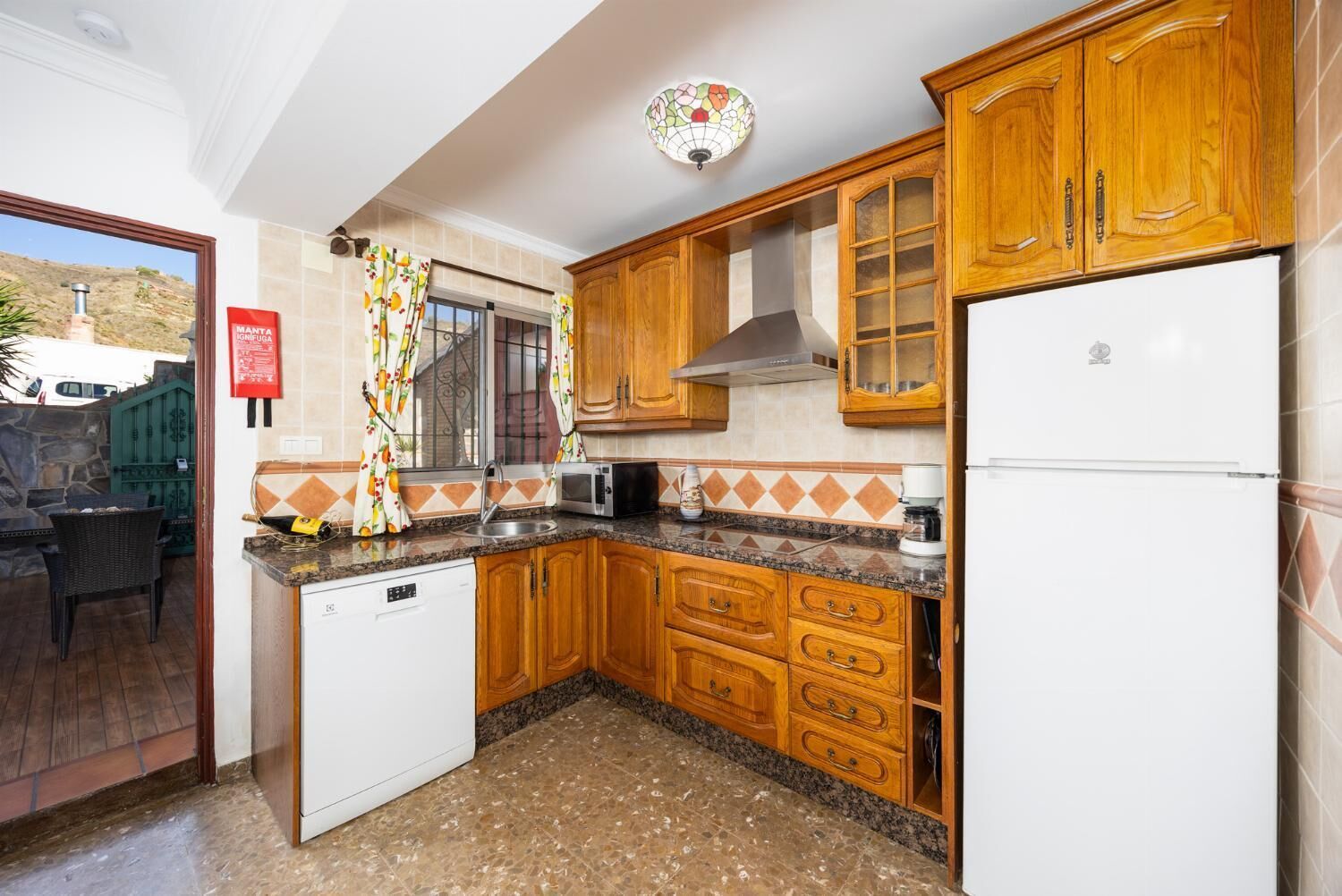 A kitchen with wooden cabinets, a microwave, a stove, and a refrigerator.