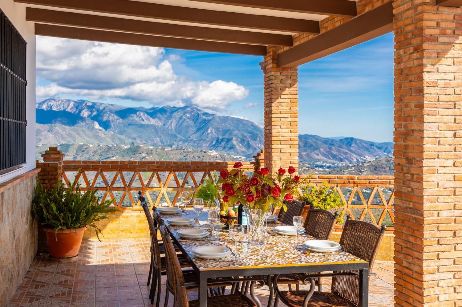 A terrace with a table set for dining, featuring a mountain view.