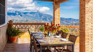 A terrace with a table set for dining, featuring a mountain view. - Villa Baena in Macaca (Torrox)