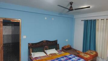 A bedroom with a bed, a ceiling fan, and a window with curtains.