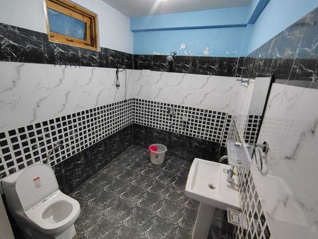 Un baño con inodoro, lavamanos y ducha. Las paredes tienen diseños en blanco y negro.