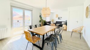 Eine moderne Wohnung mit Essbereich, einer Sofagarnitur und einem großen Fenster.