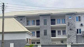 A multi-story building with a modern design, featuring balconies and large windows. - Lavish Apartment (Abuja)
