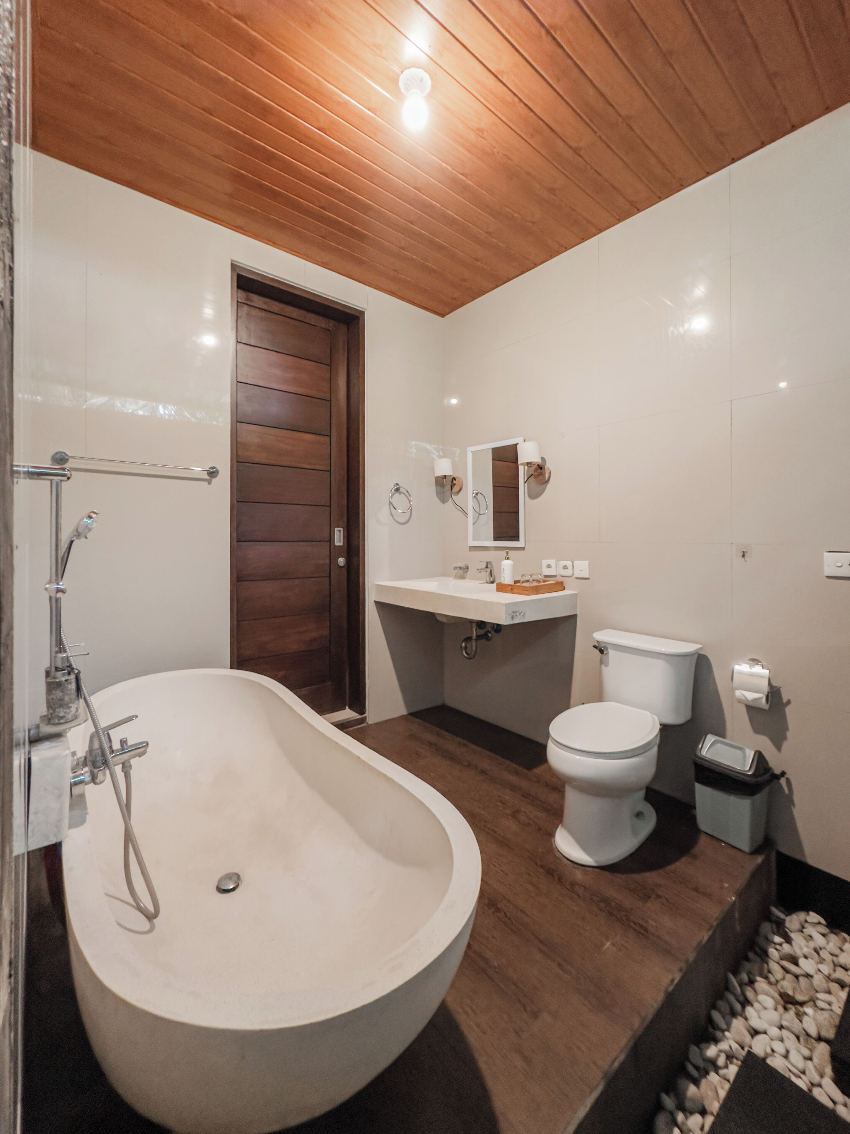 A bathroom with a freestanding bathtub, a toilet, a sink, and a mirror.