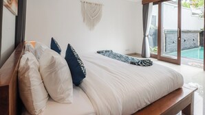Un dormitorio moderno con una cama grande, un banco de madera y vista a una piscina a través de amplios ventanales correderas.