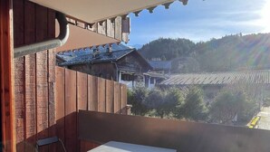 A balcony with a table and chairs, overlooking a mountainous landscape. - Nice Apt for 4 pers mountain view (Morillon)