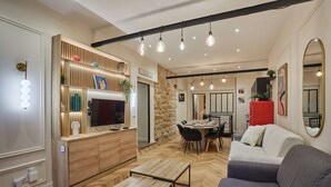 A modern living room with a sofa, a coffee table, and a dining area with a table and chairs. - Sublime apartment in the heart of Paris 10 people (Paris)