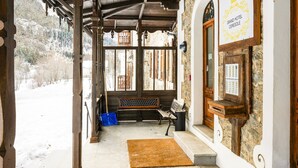 A covered porch with wooden beams, a bench, a stone wall, and a sign for the Grand Hotel Ceresole. - In the historic building, con aria condizionata (Ceresole Reale (TO))