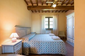 A bedroom with a bed, bedside tables, a lamp, a window with curtains, and a radiator. - Beautiful farmhouse with swimming pool (Città di Castello)