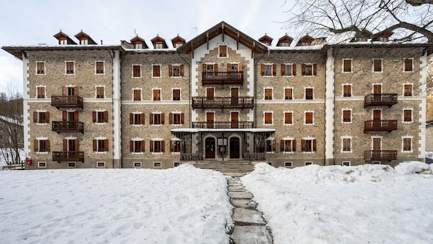 A large stone building with multiple balconies and a central entrance.