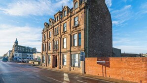 A historic building with multiple stories, large windows, and a prominent corner entrance. - Dockside: Quay Views, City Vibes (Dundee)