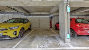 Un parking où deux voitures sont garées dans des emplacements prévus à cet effet.