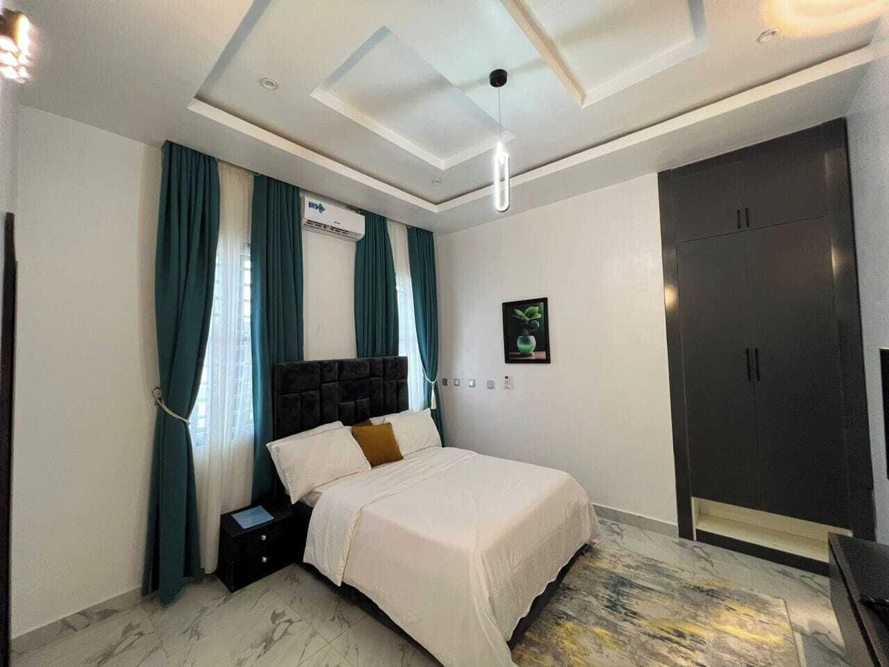 Un dormitorio con cama, mesita de noche, armario y equipo de aire acondicionado.