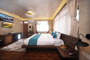 A modern hotel room with a large bed, a desk, a television, and a view of the outdoors. - Tibet Boutique Hotel Annex (Kathmandu)