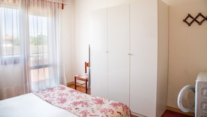 Ein Schlafzimmer mit Bett, Stuhl, Kleiderschrank und Waschmaschine.