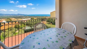 Un balcón con mesa y sillas, con vistas a un paisaje pintoresco.