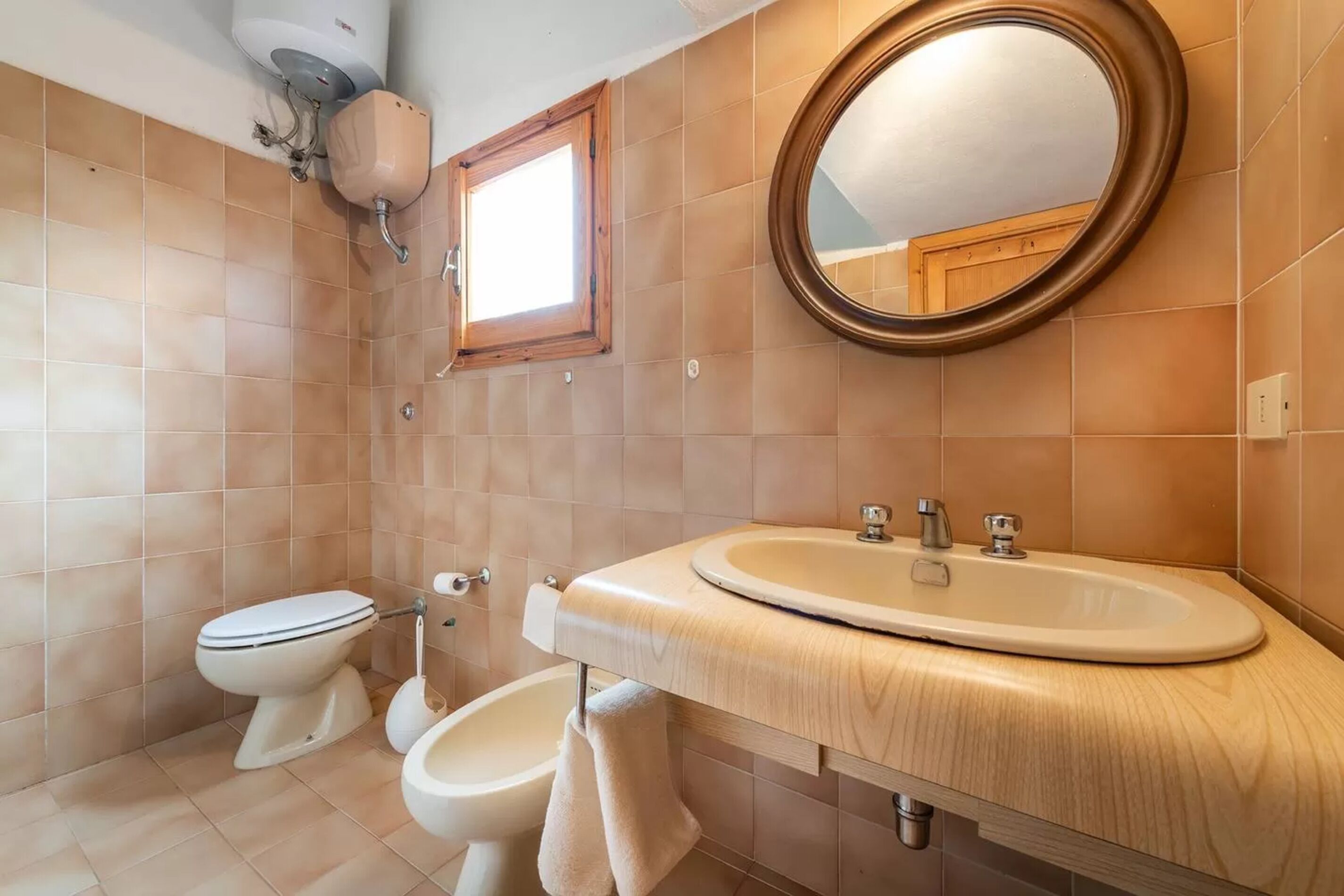 A bathroom with a toilet, bidet, and sink.