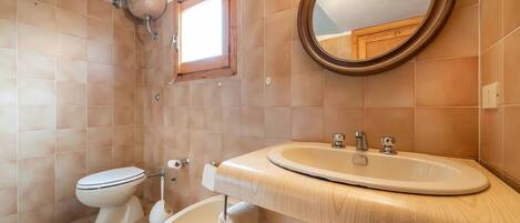 A bathroom with a toilet, bidet, and sink.