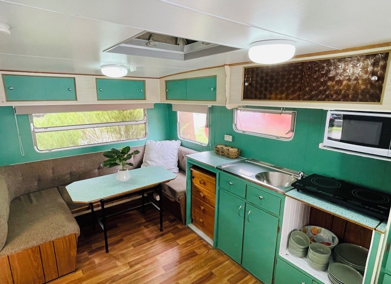 A compact kitchenette with a dining area, a microwave, and a sink.