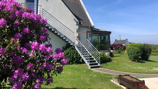 A house with a grey exterior, a visible staircase, and a glass door leading to the entrance. - Studio "Port Lazo" with Sea View, Private Terrace and Wi-Fi (Plouézec)