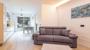 Una sala de estar moderna con un sofá gris, una mesa de centro de madera y un cuadro en la pared.