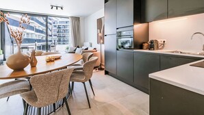 Une cuisine moderne avec des meubles de couleur sombre, un four encastré et un évier.