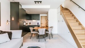 Un espace de vie moderne comprenant une cuisine, un coin repas et un escalier.