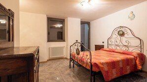 A bedroom with a bed, a dresser, a radiator, and a window. - Wonderful private villa for 4 guests with WIFI, TV, terrace and pets allowed (Talamona)