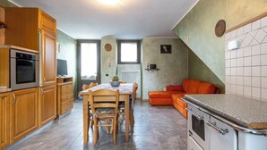 A kitchen with wooden cabinets, a dining table with chairs, a built-in oven, and a tiled backsplash. - Wonderful private villa for 4 guests with WIFI, TV, terrace and pets allowed (Talamona)