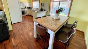 Uma cozinha compacta com área de refeições, piso de madeira e ventilador de teto.