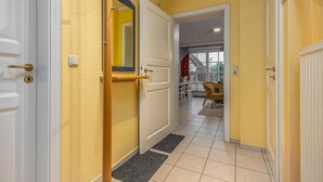 Un corridoio con pareti gialle, porte bianche e stipite in legno.