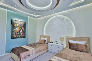 Un dormitorio moderno con dos camas, una mesita de noche y un adorno en la pared.